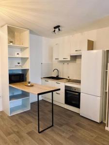 a kitchen with a table and a white refrigerator at Charmant T2 moderne /proximité CDG / Confort in Villepinte