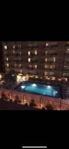 a large building with a swimming pool at night at الدقى ميدان المساحه أمام فندق سفير in Cairo