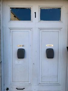 une porte blanche avec deux fenêtres. dans l'établissement Le Fauverney, à Fauverney