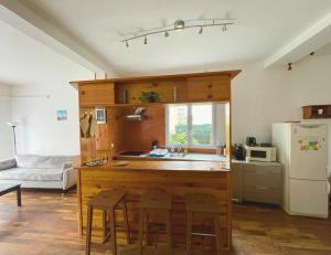 uma cozinha com um lavatório e um balcão com bancos em 9 min from Paris&Orly - House with terrace/garden em Arcueil