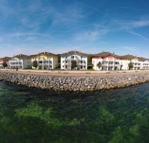 a row of houses next to the water at BEECH Resort Boltenhagen in Boltenhagen