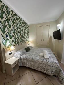 1 dormitorio con 1 cama y un mural en la pared en Camere Chicca, en San Remo