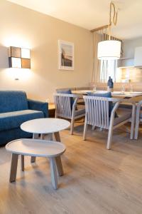uma sala de estar com duas mesas e um sofá em BEECH Resort Boltenhagen em Boltenhagen