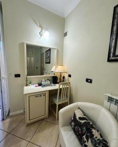 sala de estar con sofá y escritorio con espejo en Camere Chicca, en San Remo