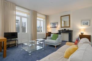 a living room with a couch and a tv at Vondelparkmuseum Inn in Amsterdam