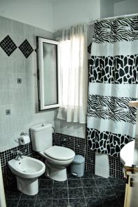La salle de bains est pourvue de toilettes et d'un rideau de douche. dans l'établissement Nikis apartment, à Larissa