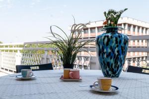 a table with a vase and two cups of coffee at ShortMi Balilla in Milan