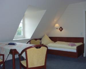ein Schlafzimmer mit einem Bett und einem Tisch und Stühlen in der Unterkunft Komenský Gäste- und Tagungshaus in Herrnhut