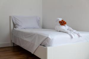 a white bed with a stuffed animal on it at ShortMi Balilla in Milan