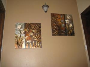 tre immagini appese a un muro in una stanza di Rouse Homestays a Couva