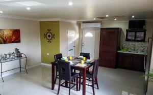 una cucina e una sala da pranzo con tavolo e sedie di Rouse Homestays a Couva