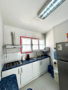 uma cozinha com armários brancos e um forno com placa de fogão em Viva Chile Providencia - Bustamante em Santiago