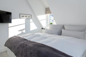 Cama blanca en habitación con ventana en NEU 2023 - Sylter Meerwind, en Westerland