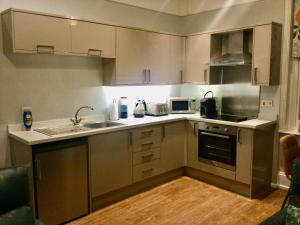 a kitchen with white cabinets and a sink and appliances at Stylish Flat in Yeovil Somerset in Yeovil