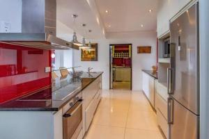 a kitchen with red and white cabinets and a refrigerator at ICON Living in Cape Town