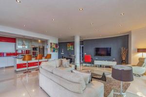 a living room with two couches and a kitchen at ICON Living in Cape Town