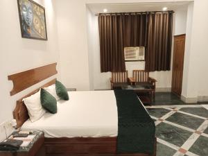 a bedroom with a bed and a chair at Ananda Krishna Van in Vrindāvan