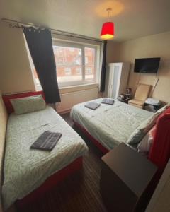 Habitación de hotel con 2 camas y ventana en PRESTIGE PLAZA Hotel, en Blackpool