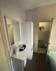 Habitación con escritorio, cama y baño. en PRESTIGE PLAZA Hotel, en Blackpool