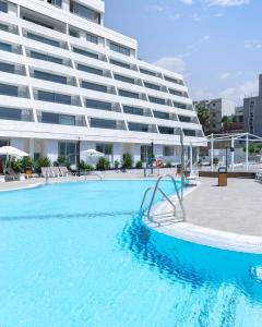 ein großer Pool vor einem großen Gebäude in der Unterkunft AKOYA HOTEL in Eilat