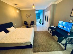 a bedroom with a bed and a desk and a television at Rove Residence New Cairo in Cairo