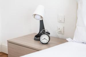 a black alarm clock sitting on a nightstand next to a bed at ShortMi Balilla in Milan