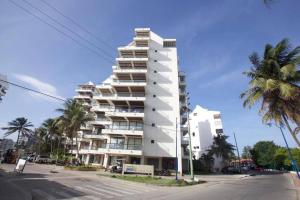 un alto edificio blanco en una calle con palmeras en GL luxury apartment 203 Bay Point, en San Andrés