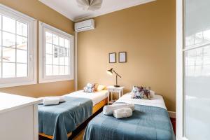 2 camas en una habitación con 2 ventanas en Ladomar Matriz, en Horta