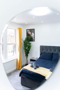 a bedroom with a blue bed and a window at Open Mind Property - 6 Luxury Bedrooms with Free Parking in Portsmouth