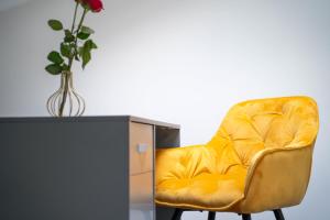 a yellow leather chair with a vase on top of a cabinet at Open Mind Property - 6 Luxury Bedrooms with Free Parking in Portsmouth