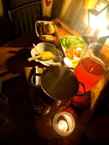 a table with a pan and a plate of food at Northernlight guesthouse in Kuusamo