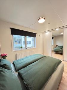 Luxurable super central 3 BR apt for a family of 6 in Oslo في أوسلو: سرير كبير في غرفة نوم مع نافذة