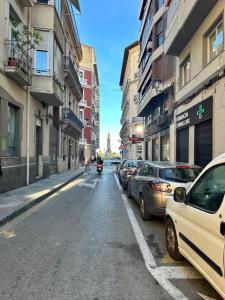 a city street with parked cars and a motorcycle at Rambla Alicante in Alicante