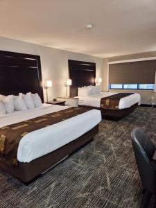 um quarto de hotel com duas camas e uma cadeira em Kelly Inn Billings em Billings