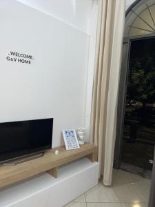 uma sala de estar com uma televisão de ecrã plano sobre uma mesa em G&Vhome em Catânia