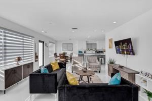 ein Wohnzimmer mit einem Sofa und einem Tisch in der Unterkunft Modern Home, Heated Pool Hot-Tub, 12min to Ocean in Miami