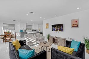 ein Wohnzimmer mit Sofas und einem Tisch in der Unterkunft Modern Home, Heated Pool Hot-Tub, 12min to Ocean in Miami