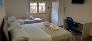 a room with two beds and a desk and a chair at B&B Omnia Scilla in Scilla