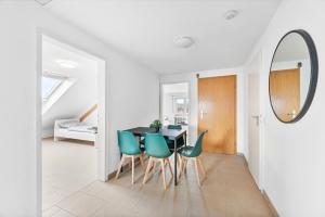 comedor con mesa y sillas verdes en MONTEURWOHNUNG in Ebersbach EB01 RAUMSCHMIDE Apartments, en Ebersbach an der Fils