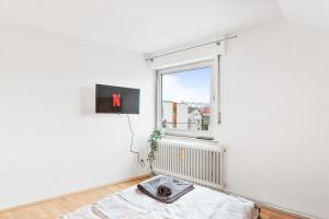 Habitación blanca con cama y ventana en MONTEURWOHNUNG in Ebersbach EB01 RAUMSCHMIDE Apartments, en Ebersbach an der Fils