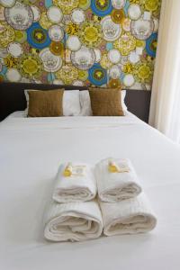uma cama branca com toalhas e uma parede em Aposentus - St Francisco Studio 20 no Porto