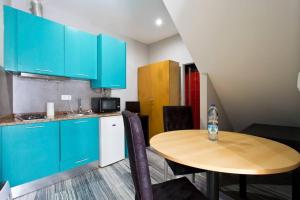 uma cozinha com armários azuis e uma mesa de madeira em Aposentus - St Francisco Studio 20 no Porto