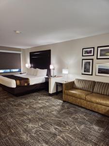 ein Hotelzimmer mit einem Bett und einem Sofa in der Unterkunft Kelly Inn Billings in Billings