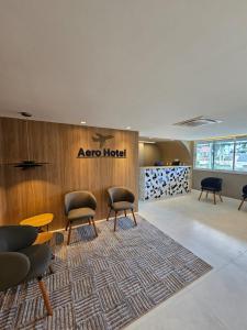 a lobby with chairs and a hotel sign on a wall at Aero Hotel in Lauro de Freitas