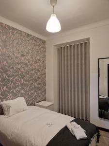 sypialnia z łóżkiem i dużym oknem w obiekcie Zuni Guest House w Lizbonie
