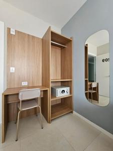 a room with a desk with a mirror and a chair at Aero Hotel in Lauro de Freitas