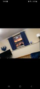 a room with a window with blue curtains at Panoramic Harbour View Apartment in Oban