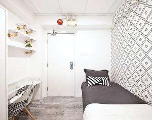 a bedroom with a bed and a chair at Pillows CoLiving in Hong Kong