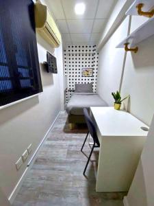 a room with a bed and a desk and a table at Pillows CoLiving in Hong Kong
