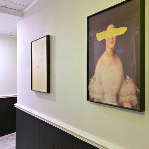 a painting of a woman with a hat on a wall at Pillows CoLiving in Hong Kong